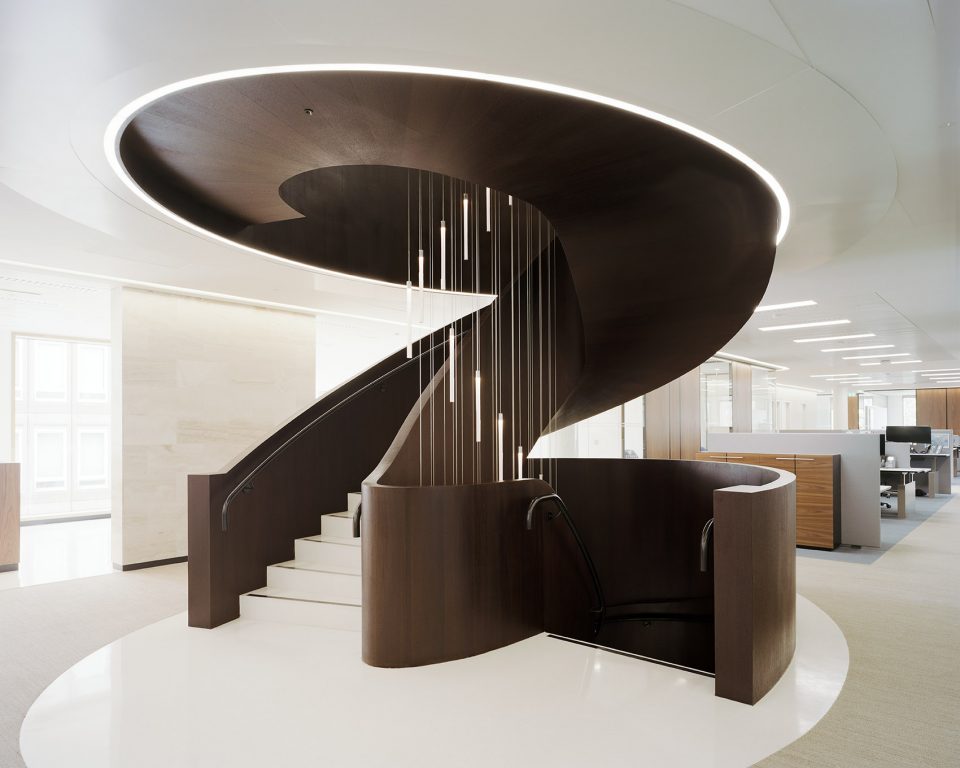 ▼楼梯坐落在以细铜管镶边的圆形白色水磨石台面上